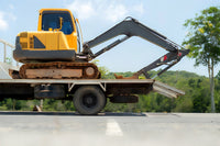 a mini excavator being transported in a properly sized trailer